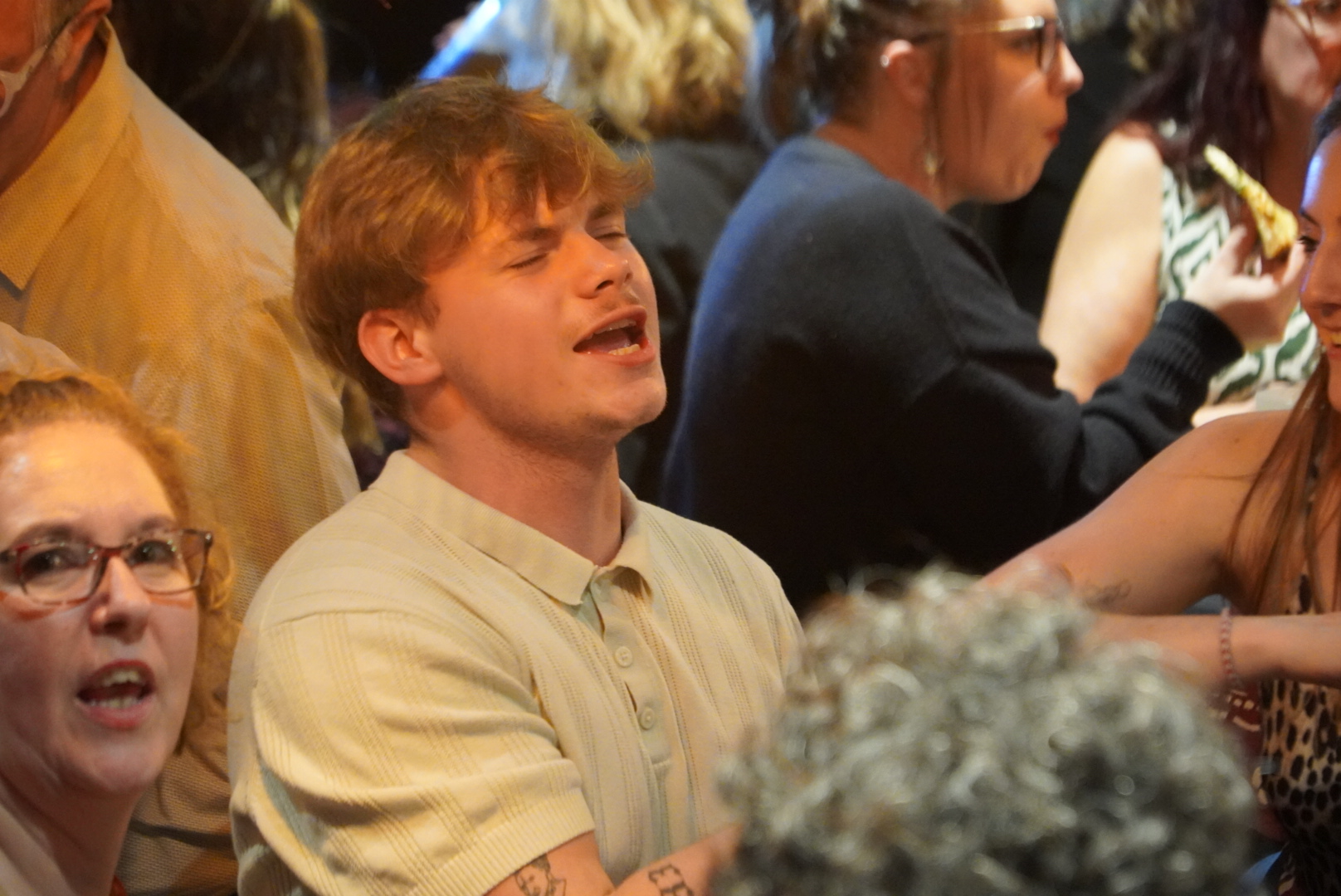 Jeune participant chantant lors d’une soirée A tue-tête