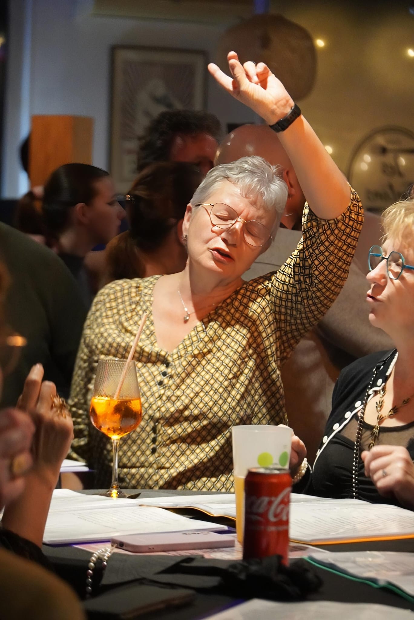 Participante senior chantant avec enthousiasme lors d’une soirée A tue-tête